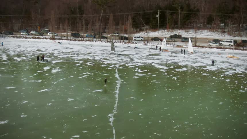 People walk on the ice of the shore