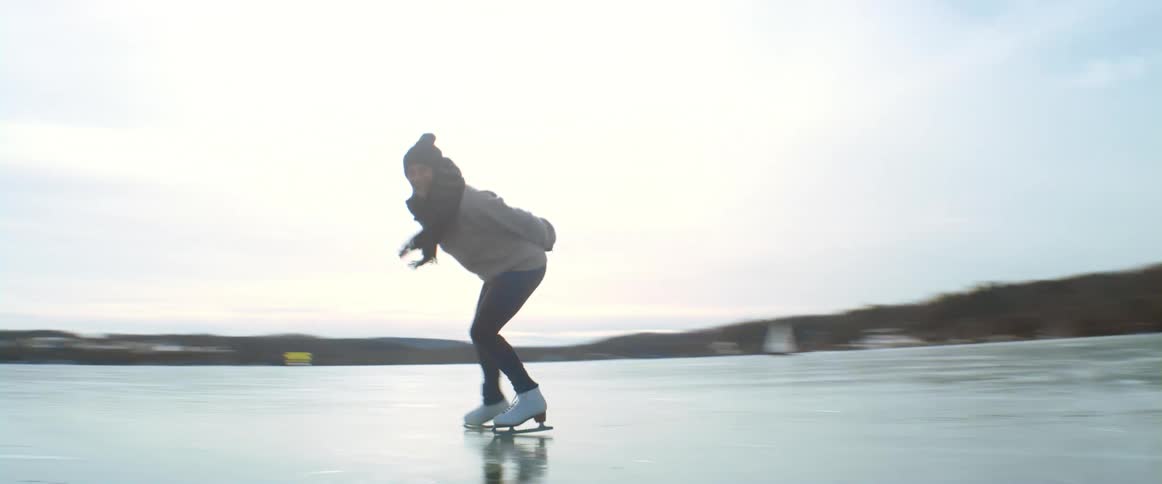 A woman is skating on the iced over lake