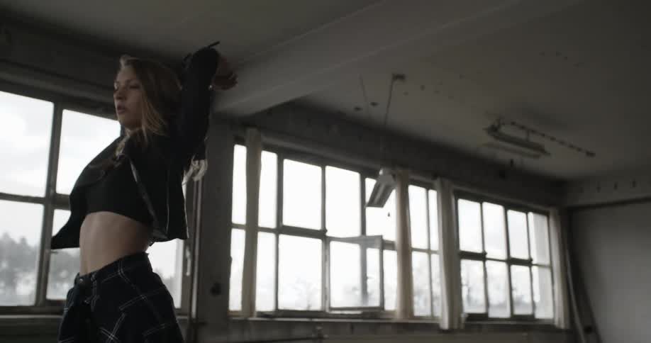 A young woman dancing in an empty room