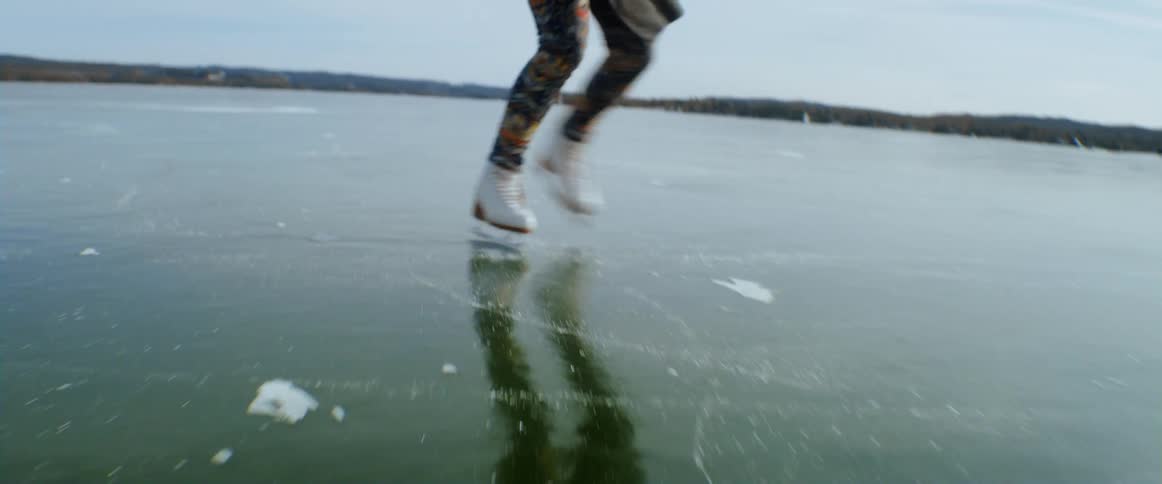 Woman ice skating at the frozen lake during day time