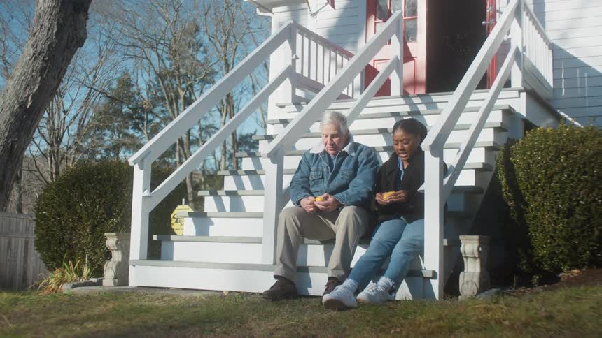 A man and woman sit on the steps talking