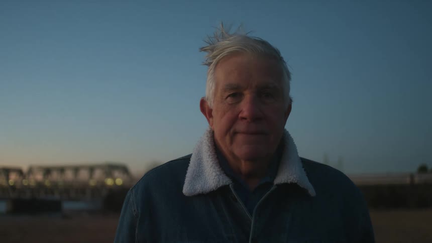 A man stands outside on a windy day
