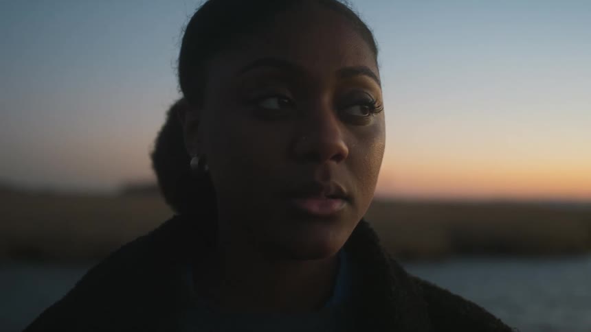 A woman blinks at sunset