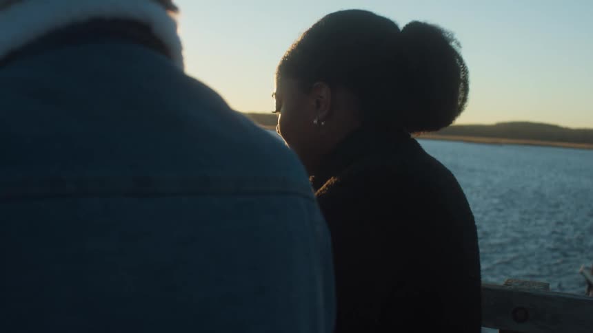 A woman talks with someone on the pier