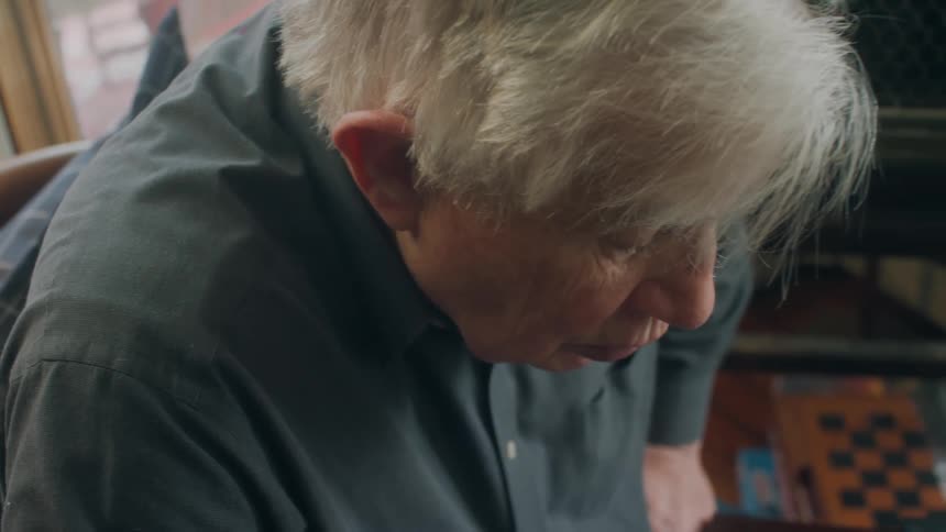 A man is leaning in the chair