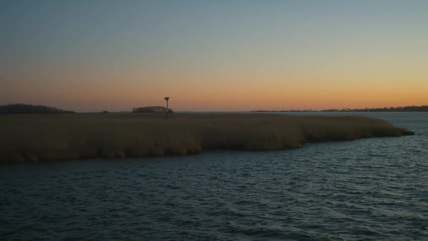 A landscape view of the sun setting over a lake