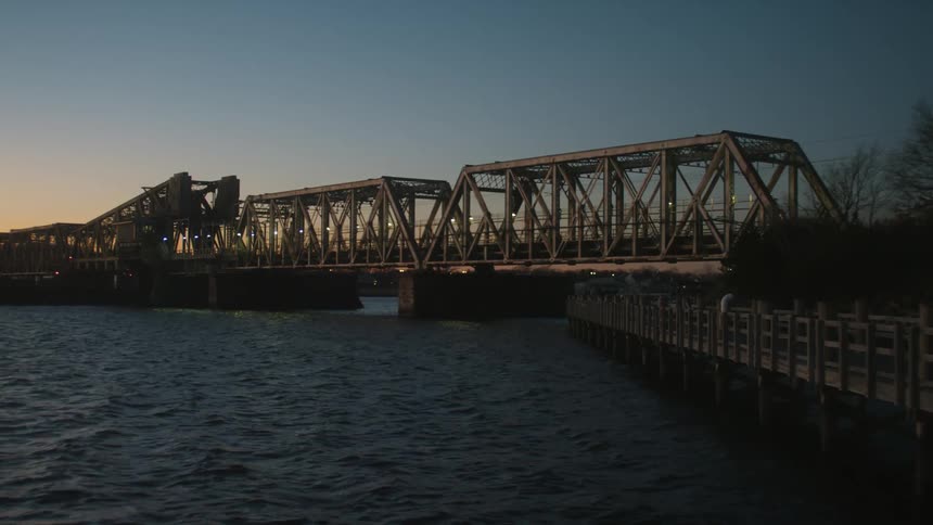 A bridge and boardwalk on a waterway at dusk
