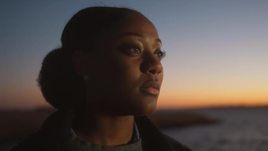 A woman is watching the sunset