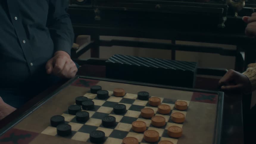 A man and woman have fun playing checkers