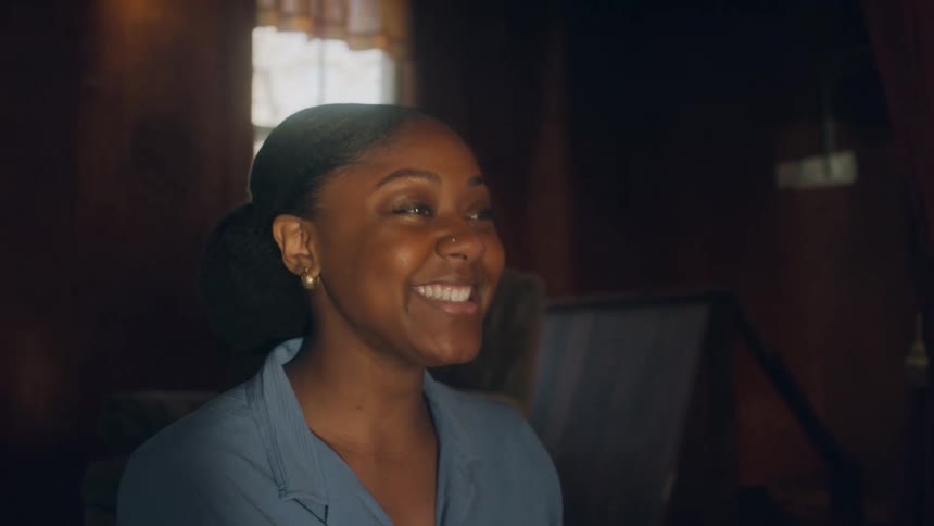 A woman laughs while relaxing and sitting at home
