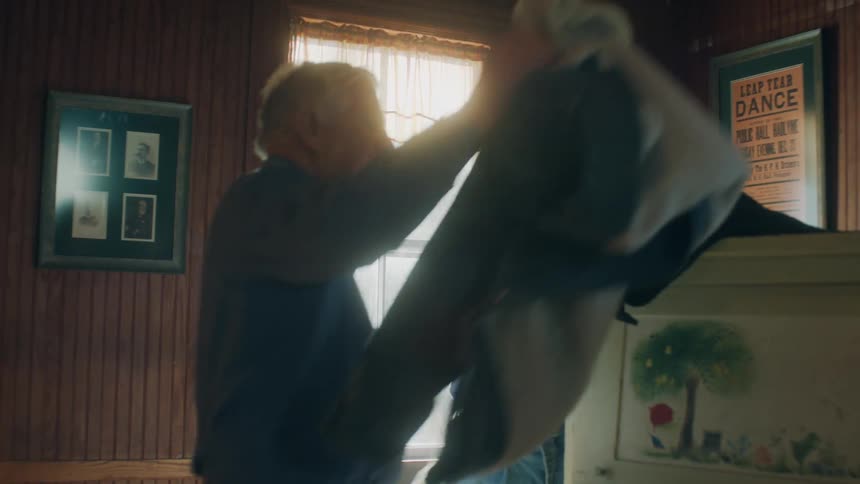 Young woman and an elderly man remove their coats then the man leads the woman to another part of the room