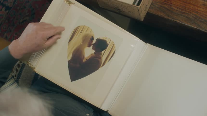 Overhead view of an elderly man looking at wedding photo in wedding album