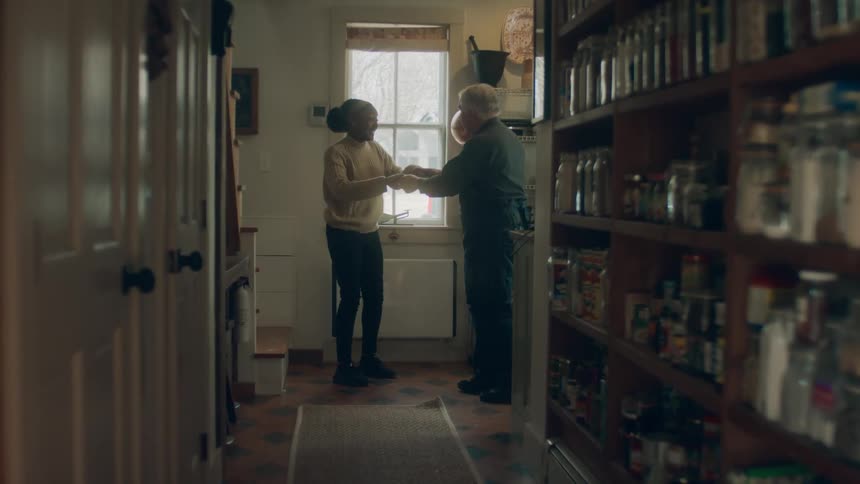 A man and woman dance down the hall