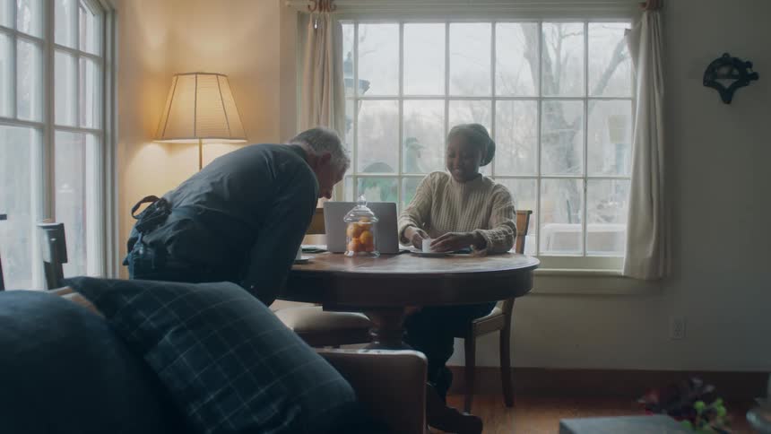 A man sits down at the table with a woman and coffee