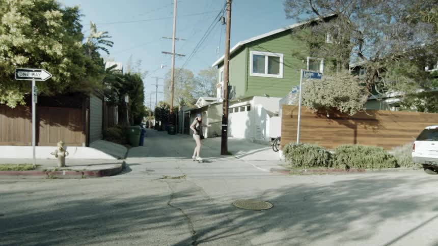 Girl skateboarding on a neighborhood side street
