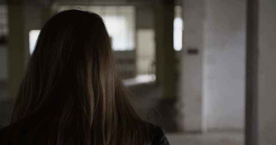 A woman walks through an empty office building during the day