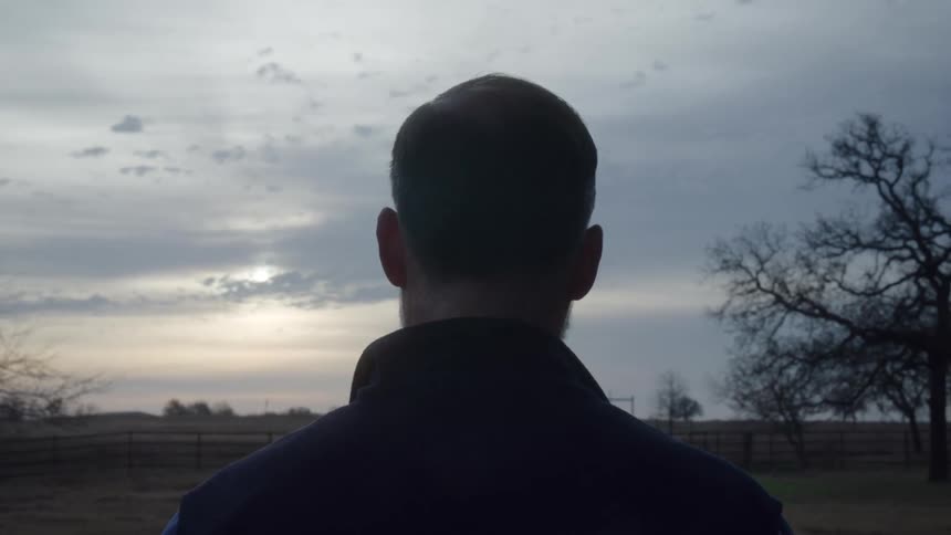 A man is watching the sun in his field