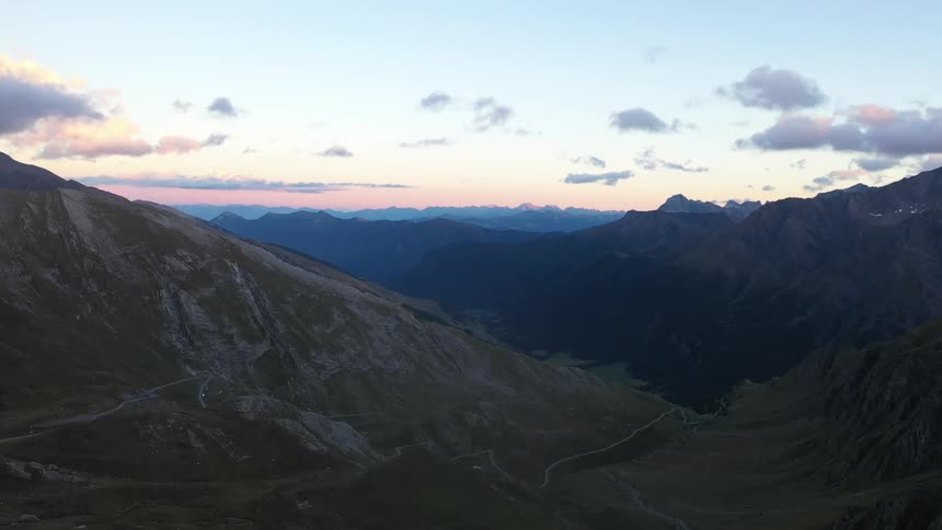 A mountain range under a cloudy sky and mountains on the horizon