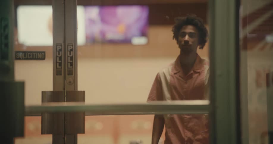 Man and woman walk out of business front door as another man watches them go