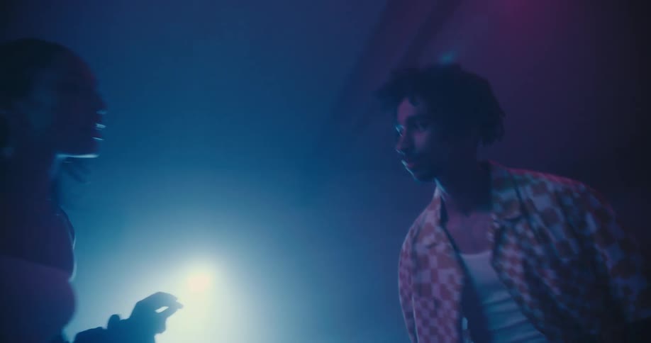 Teenagers dance and sing along to music in a club