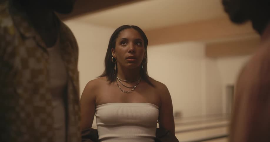 A woman looks on sadly then interferes when two men become combative