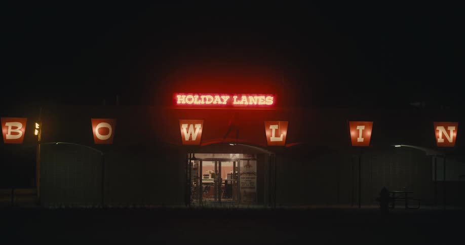 A person is dancing on the bowling alley awning
