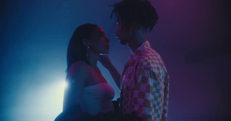 Young couple standing on the dance floor get close to each other to kiss