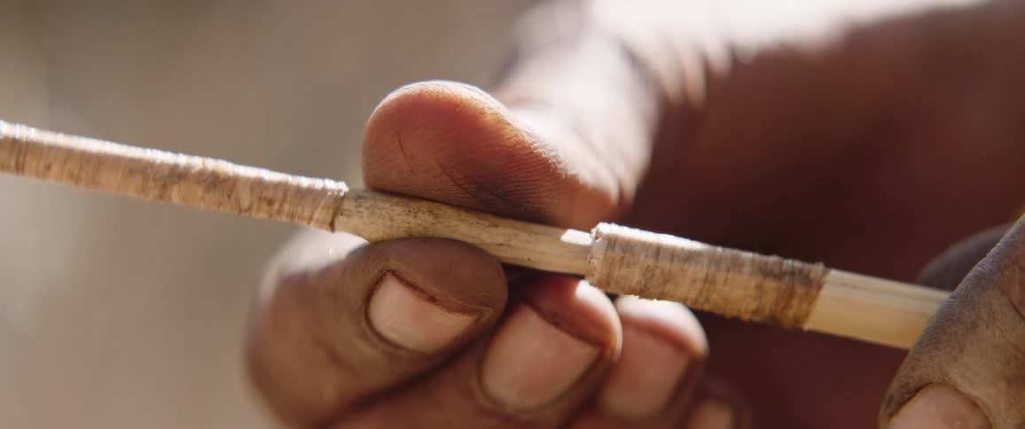 Tribal men making an arrow for hunting