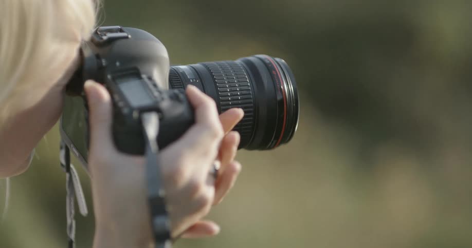 A woman is taking photographs with a large camera