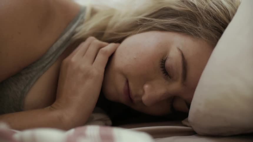 A blond woman wakes up and looks around