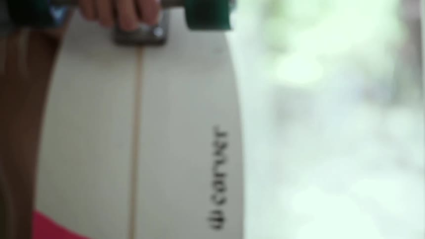 A woman picks up a skateboard and walks out the door