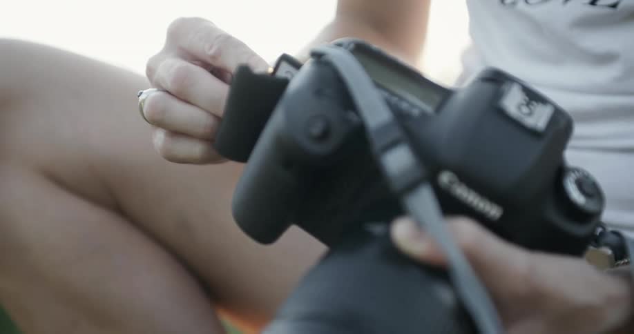 Woman loading a memory card into her canon camera
