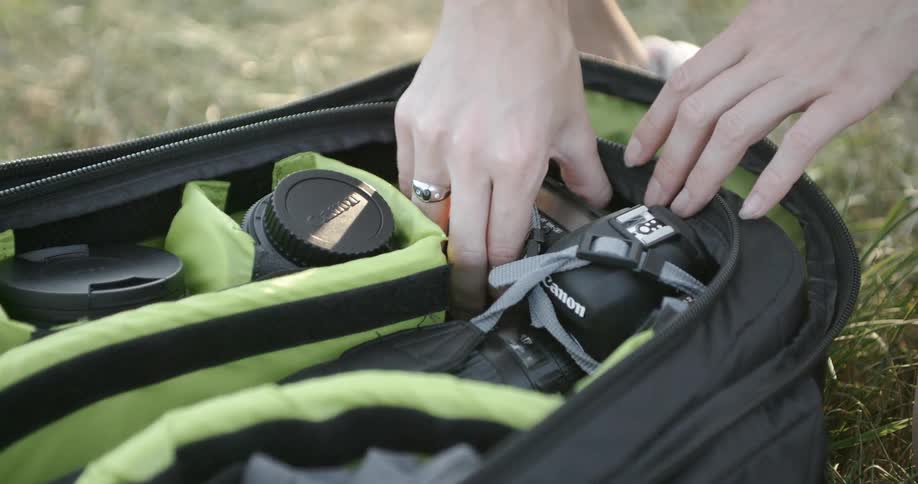 A person pulls a camera from a bag