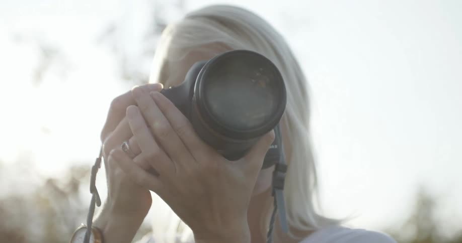 Blonde woman holding her camera up and aiming