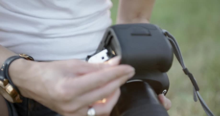 A person opens the back of a camera