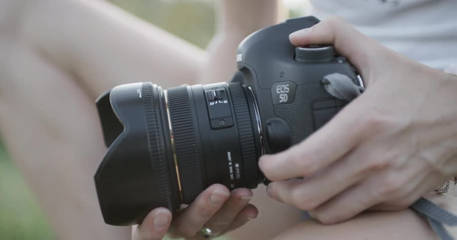 A person attaches a lens to a camera