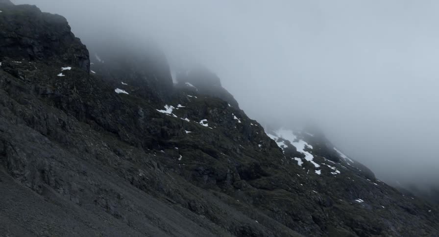 Low clouds in touch with a tall dark mountain