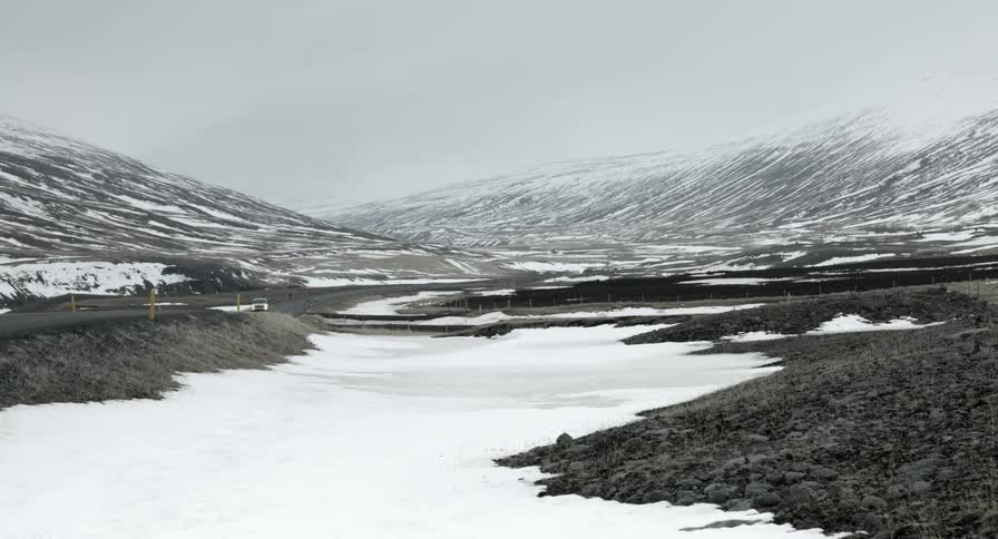 Lone vehicle driving through a snowy wilderness