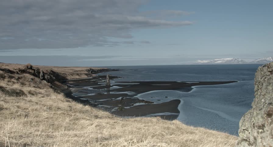 A body of water near grassy hills