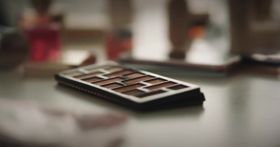 A person dips the brush in the makeup