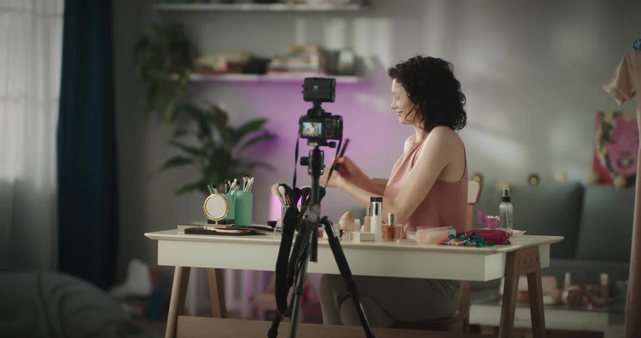 A woman films herself as she puts on make up