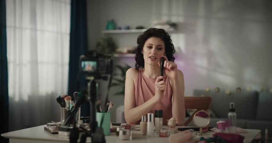 A woman is showing makeup on her camera