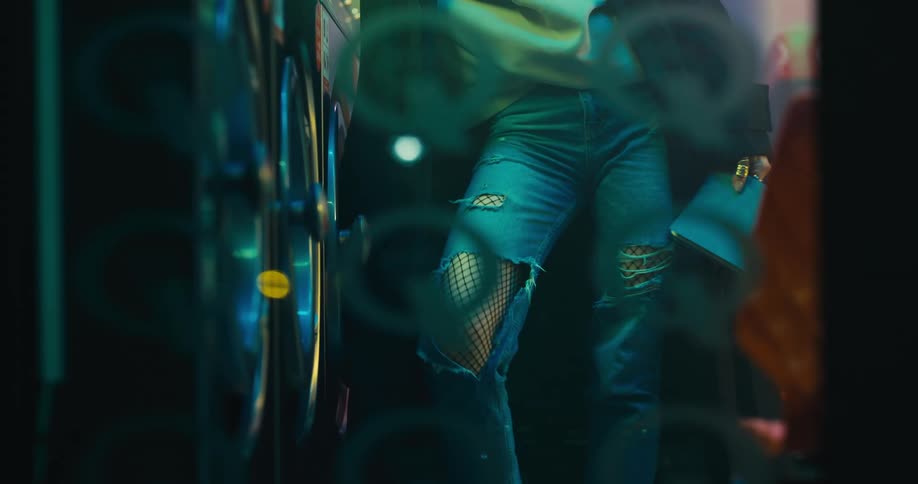 A woman is standing inside by the washing machine