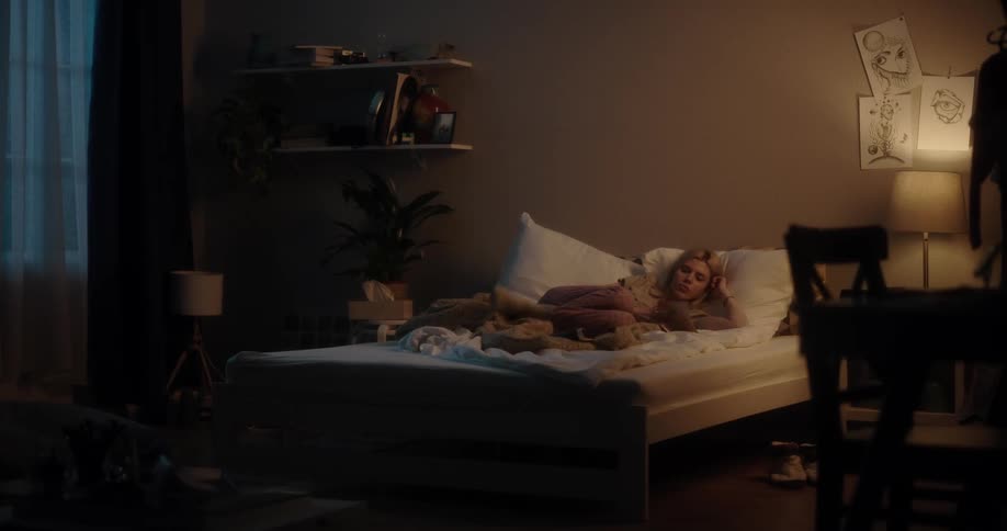 A woman fidgets and reads a magazine while resting in bed at night