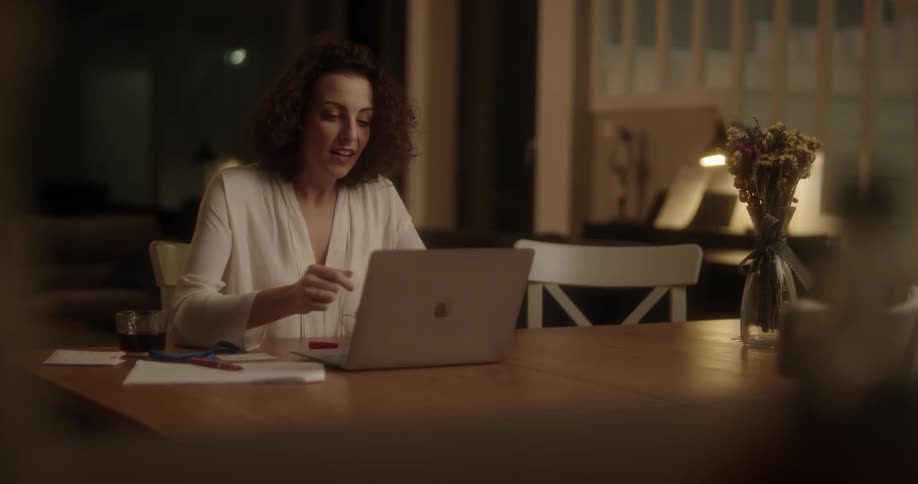 A woman finishes on a computer and a boy runs up to her