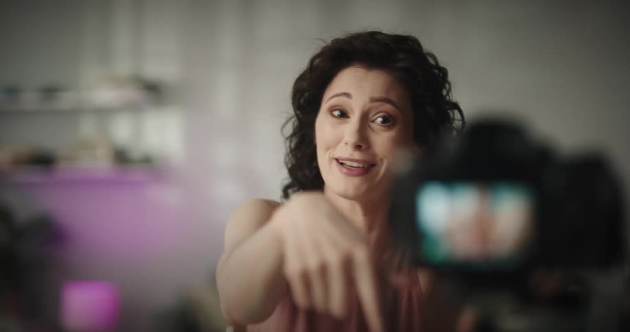 A woman sitting in a room with a camera