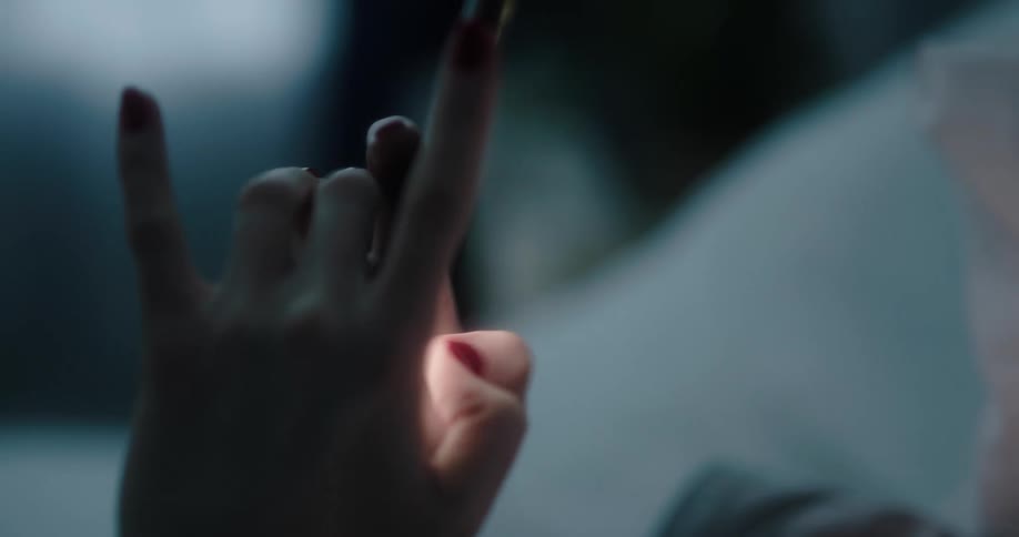 Young white woman lying in bed and texting on her smartphone