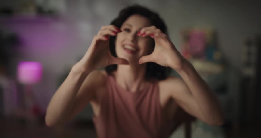 A woman applies makeup and waves