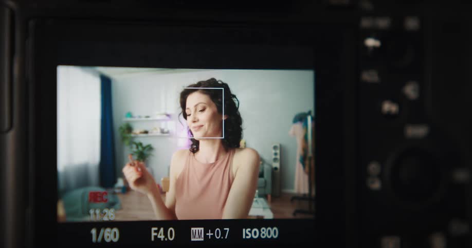 Monitor showing a woman demonstrating how to apply lipstick to her mouth
