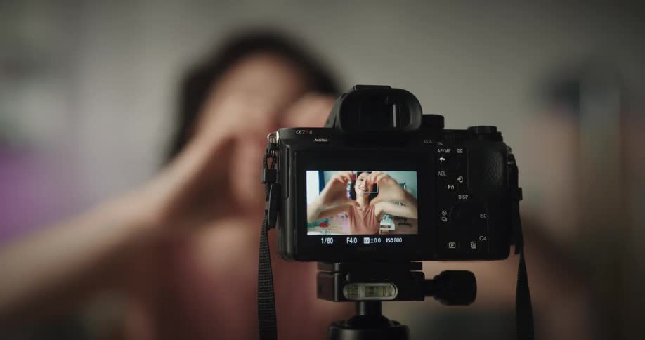White woman recording herself applying makeup and then talking and gesticulating to the camera